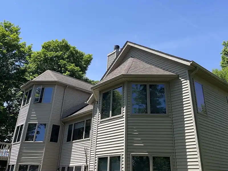 Large mid-class home with brown roof shingles